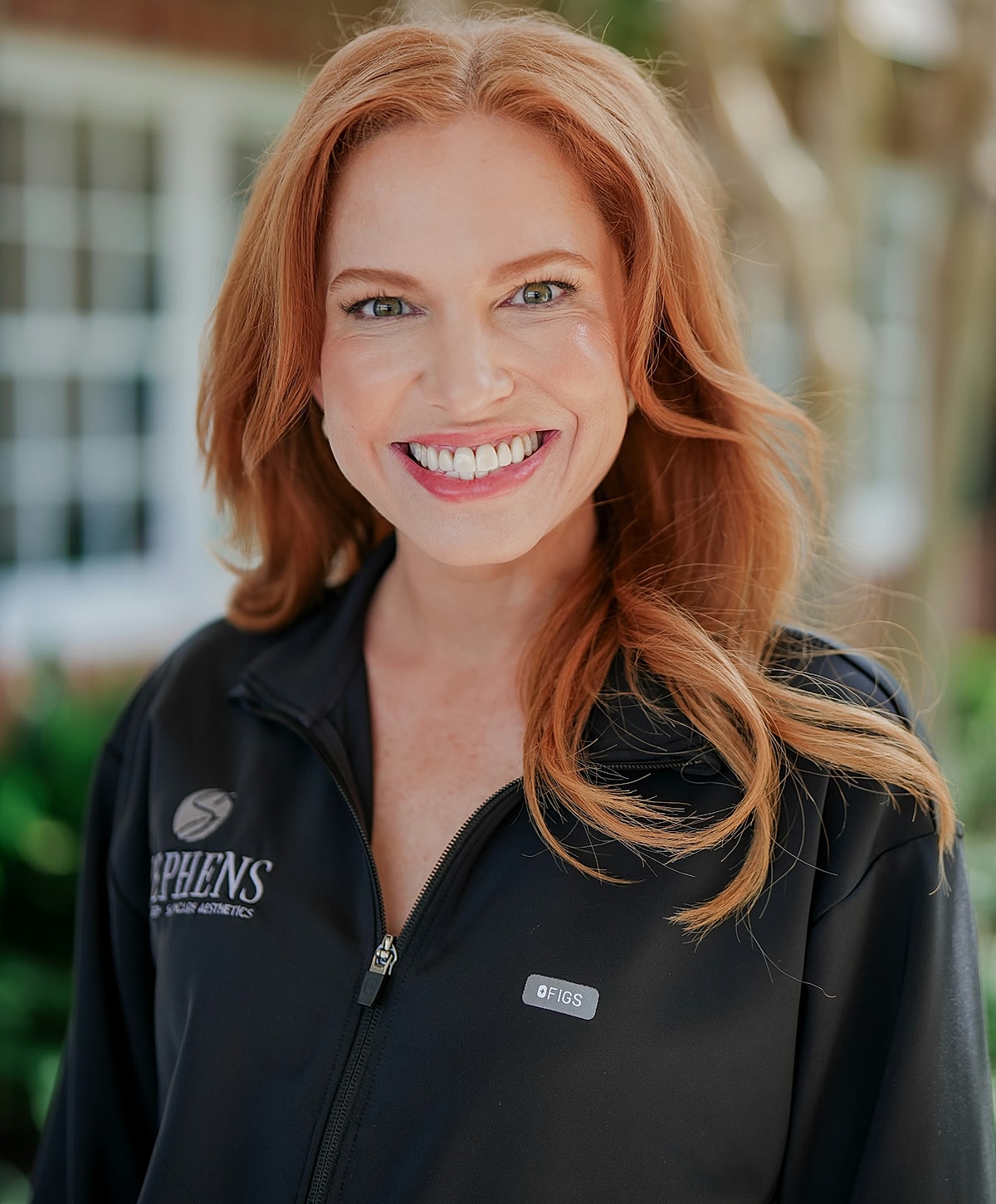 Smiling woman in professional attire outdoors.