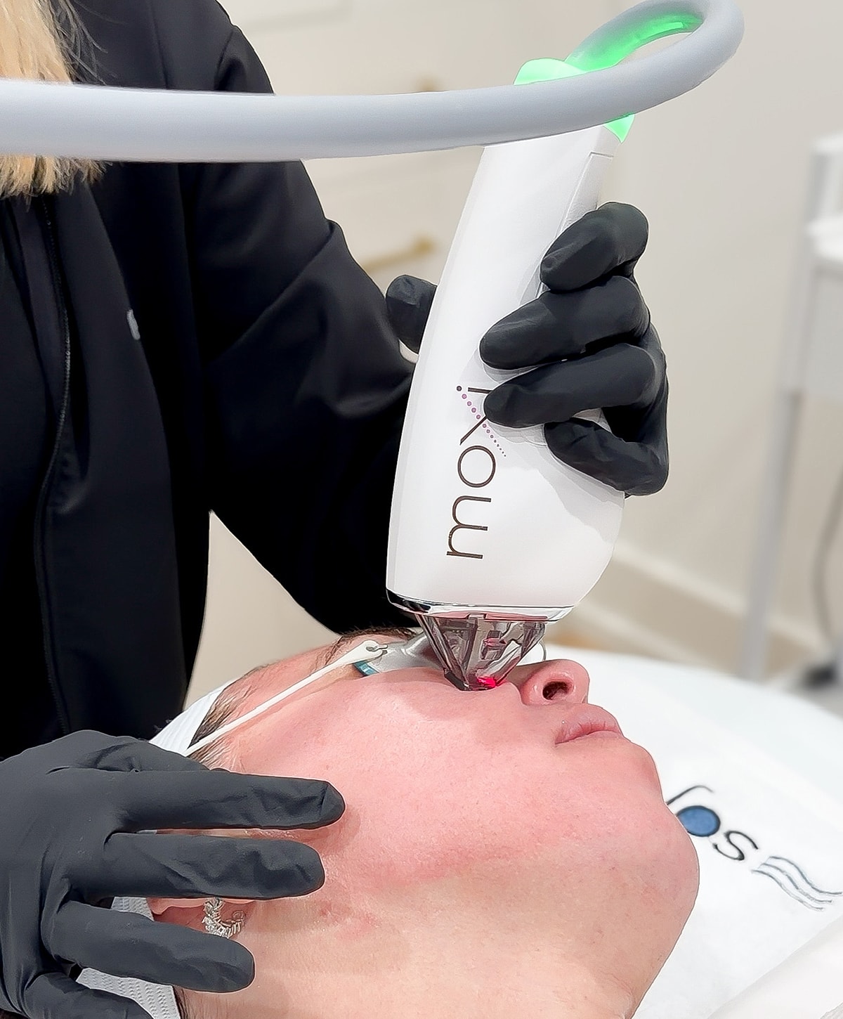 Moxi skin treatment in progress on a client's face.