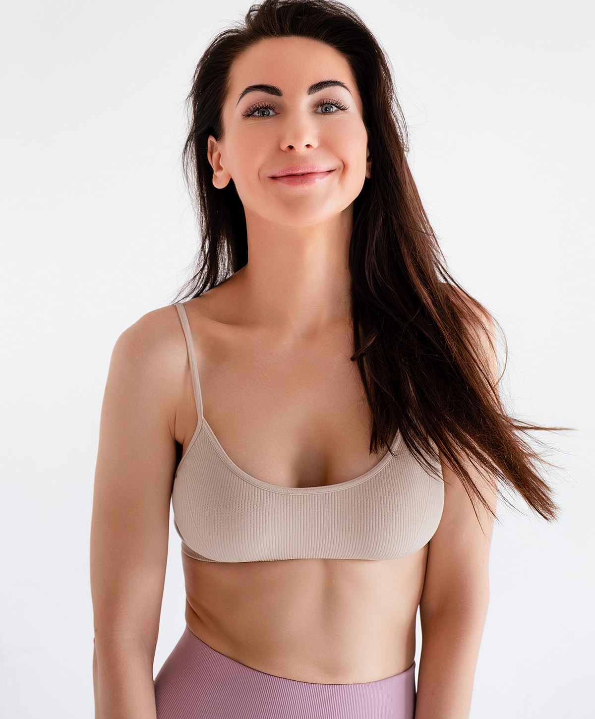 Smiling woman in a neutral sports outfit.