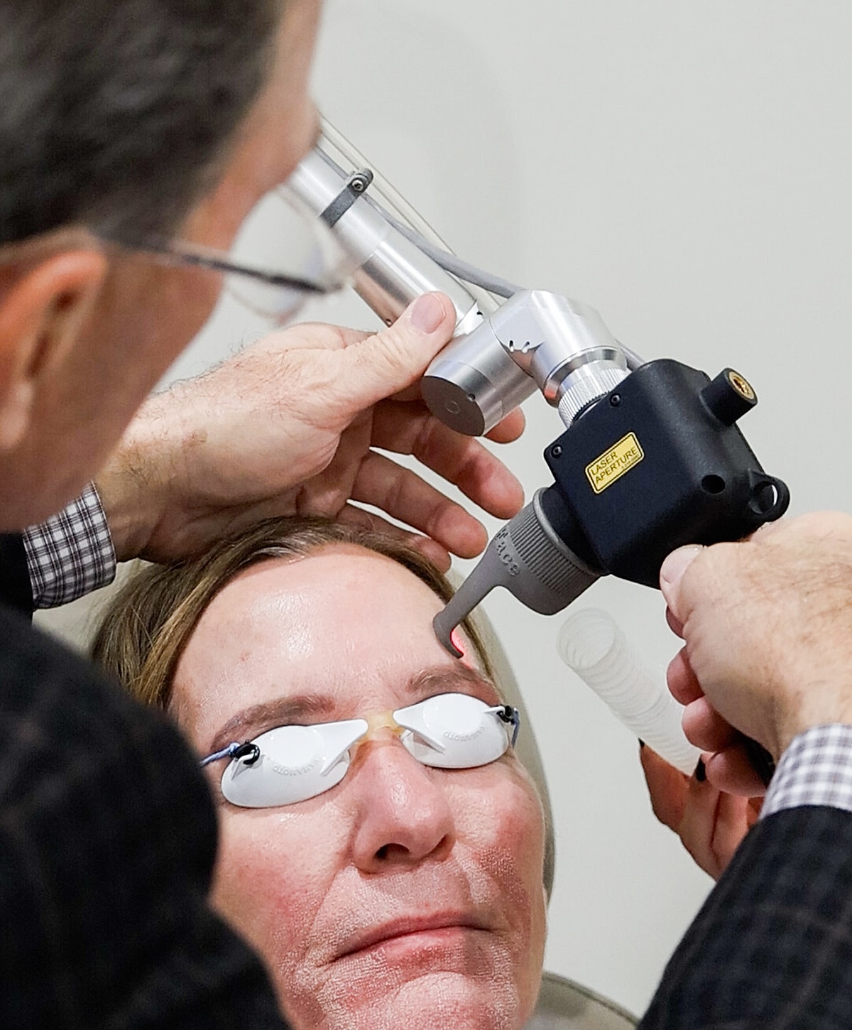 Patient receiving laser treatment on forehead.