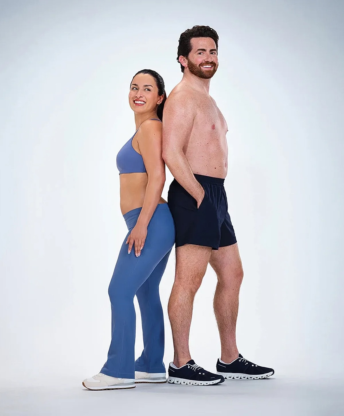 Man and woman posing back-to-back, fitness theme.