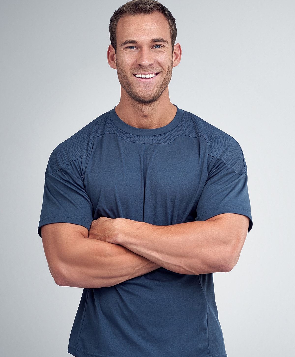 Smiling man in a blue athletic shirt.