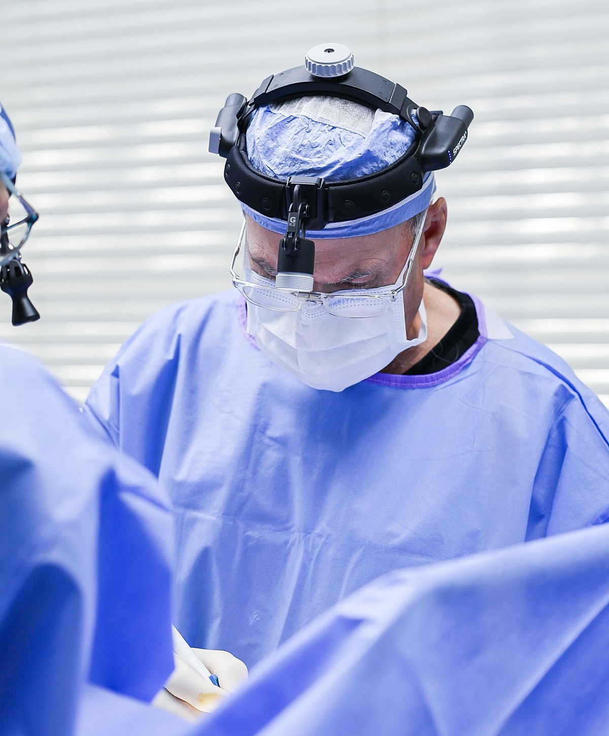 Surgeon performing operation in sterile attire.