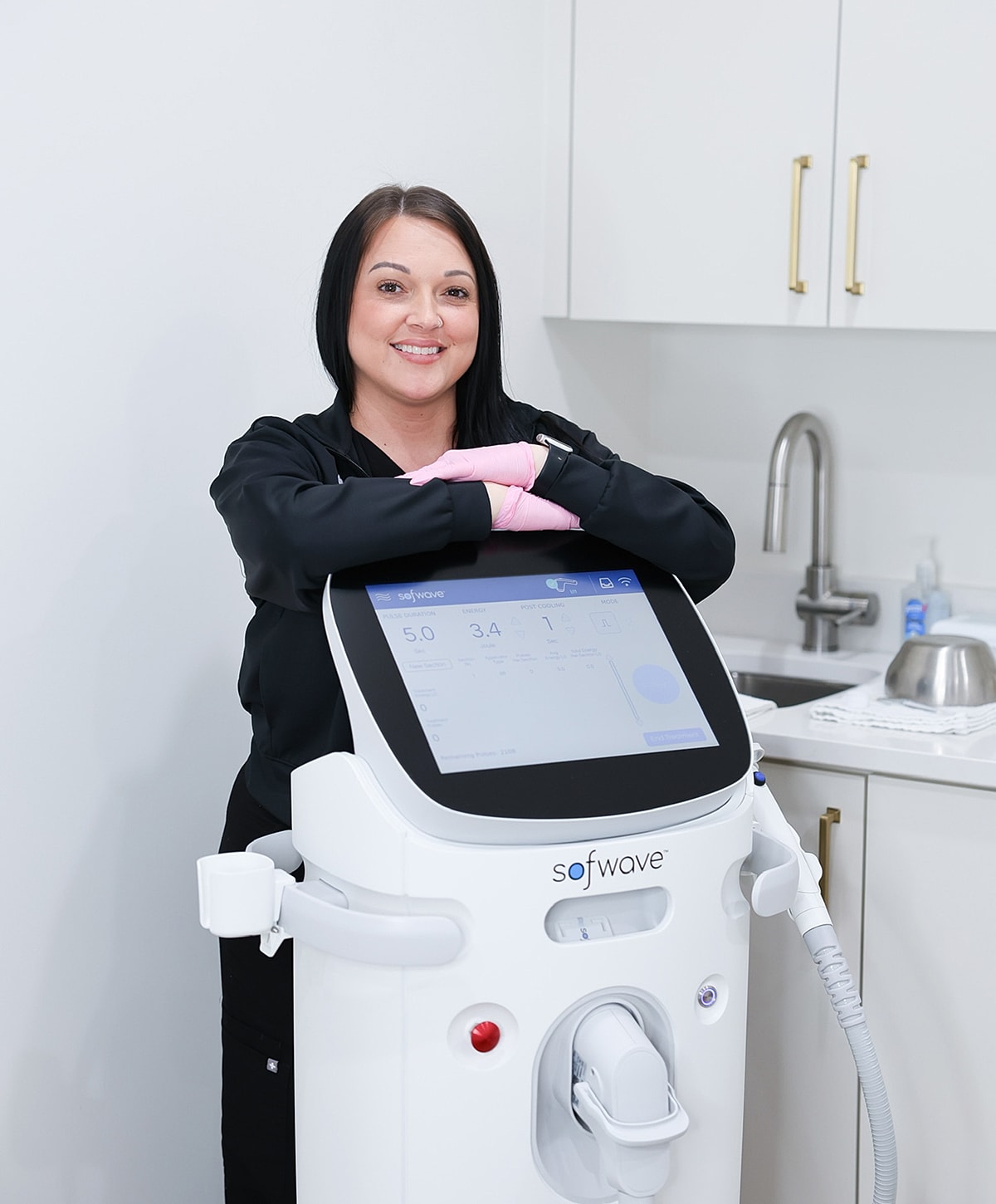 Woman with Sofwave skincare device in clinic.