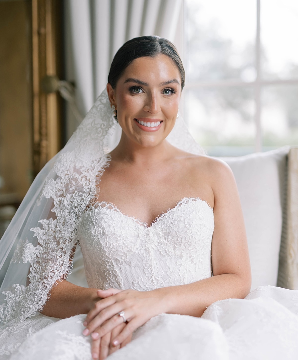 Smiling bride in elegant wedding dress and veil.