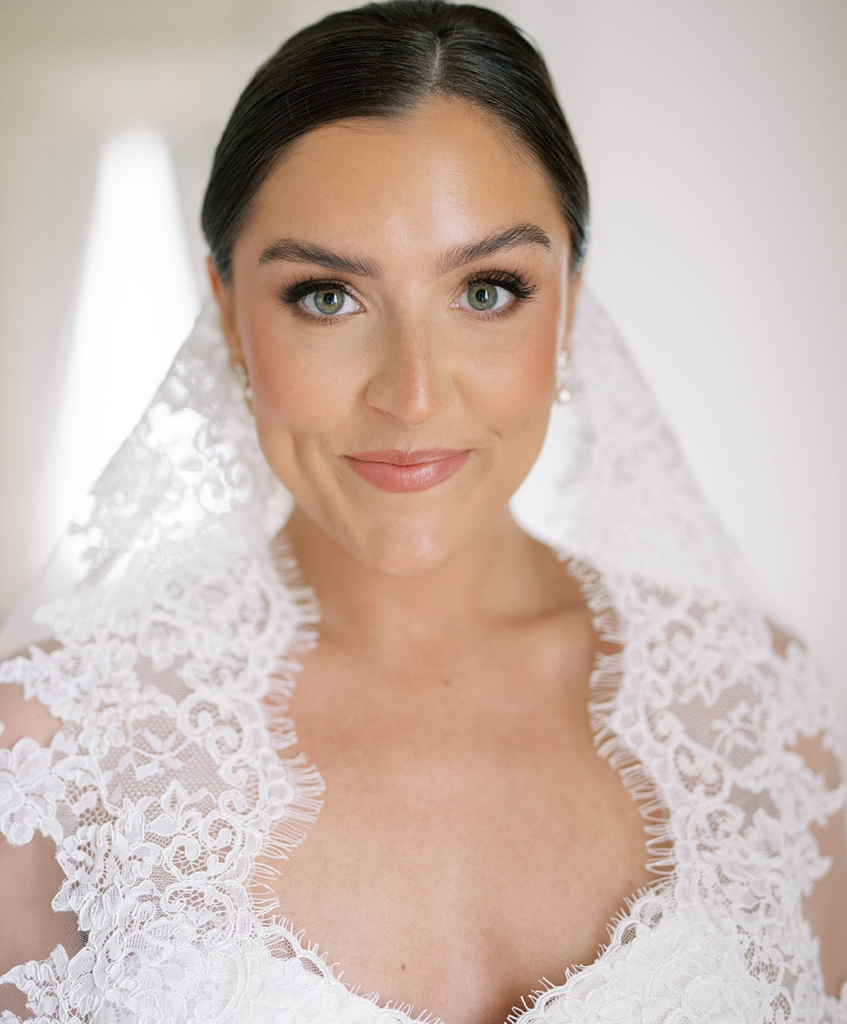 Bridal portrait with lace detailing and soft smile.