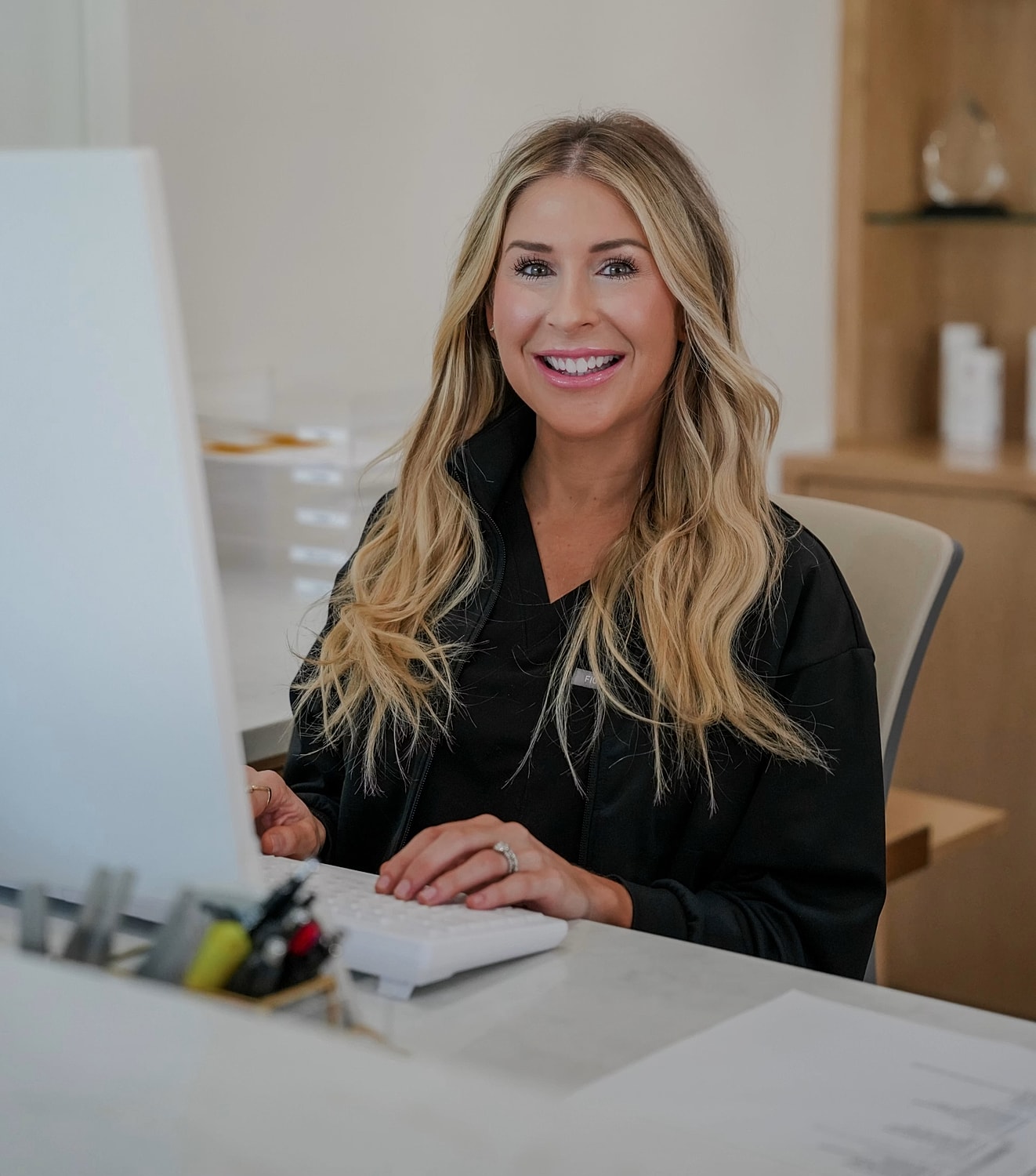 Smiling woman working at a computer desk.