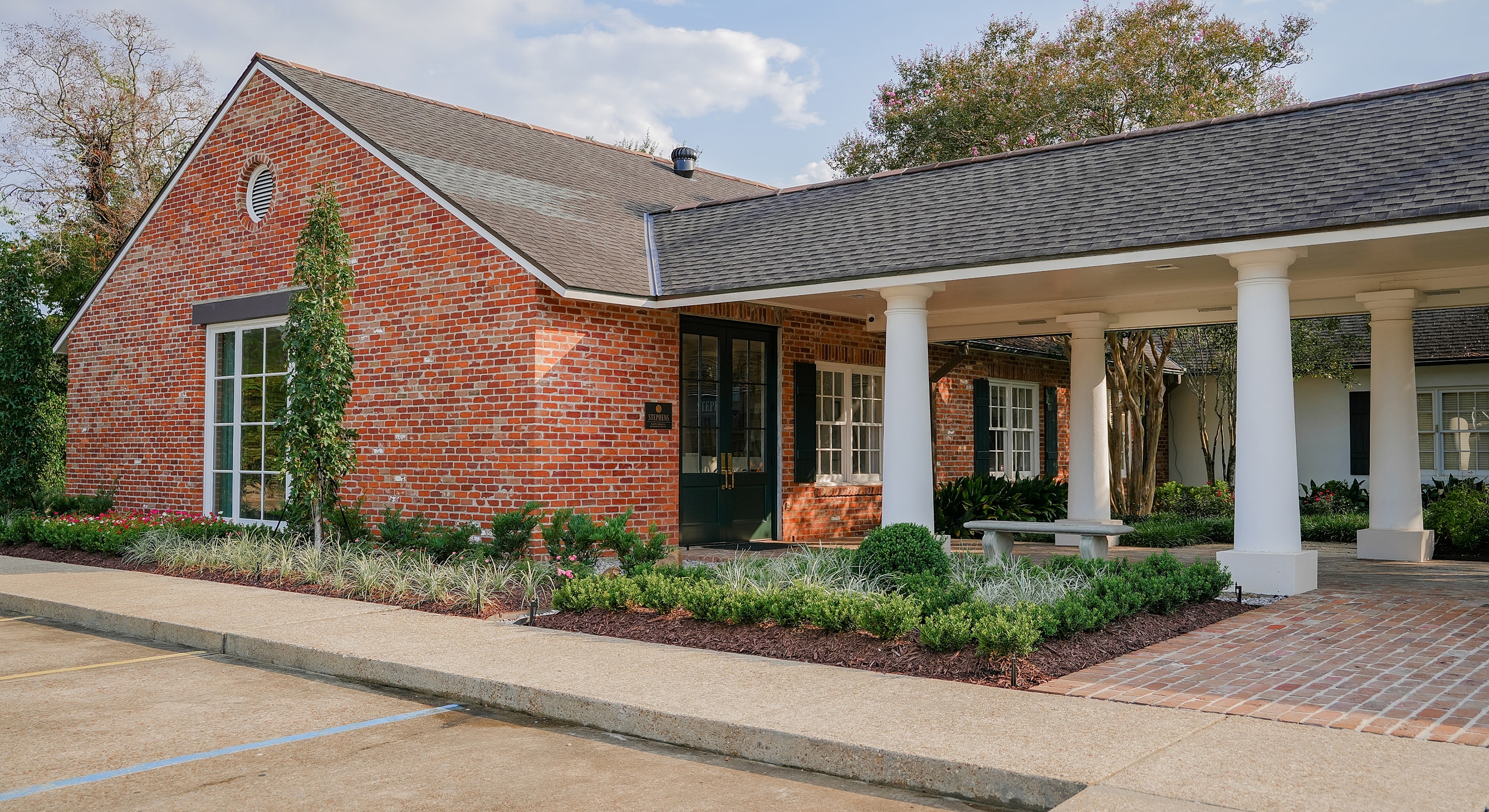 Charming brick building with landscaped entrance.