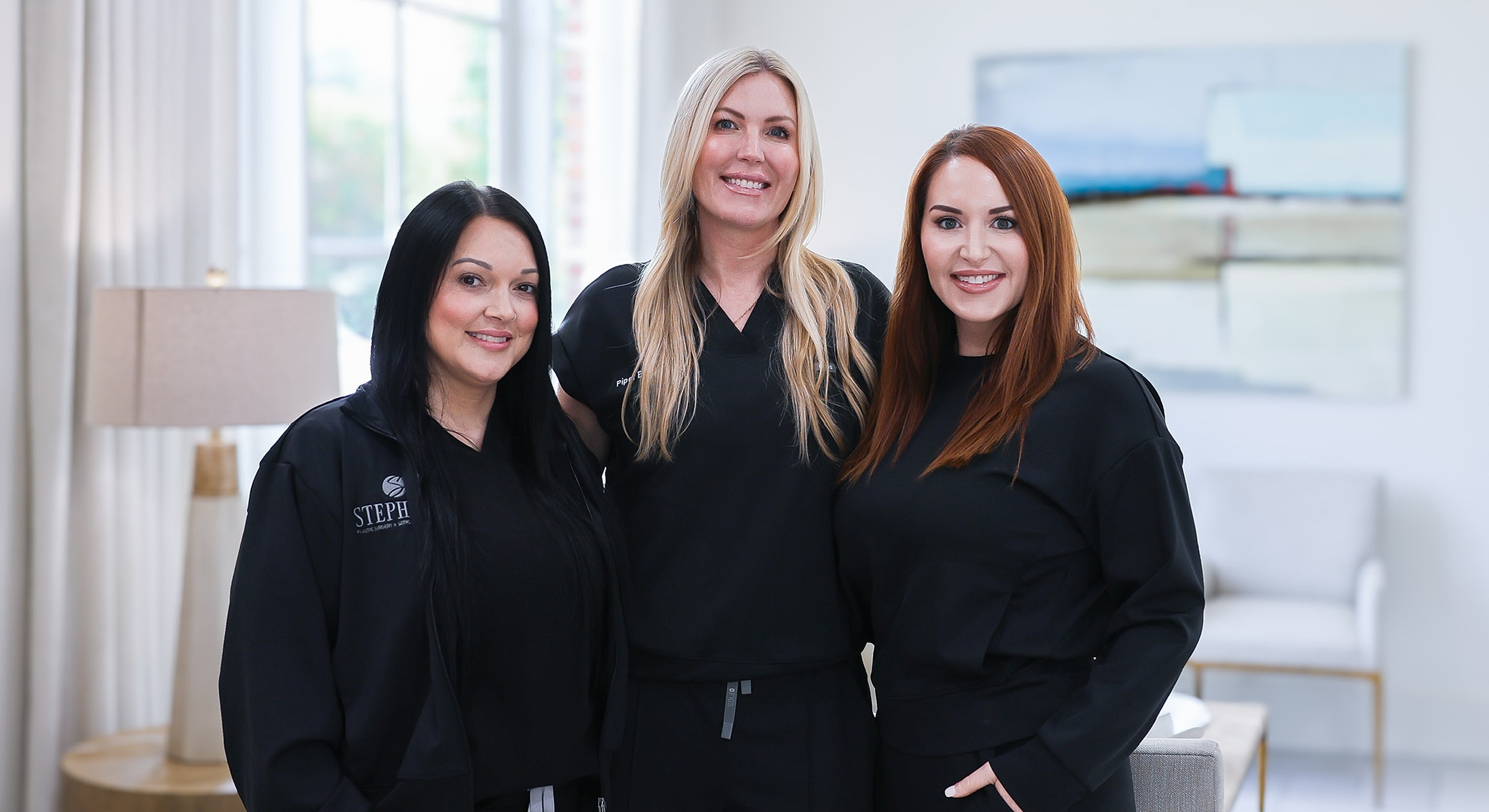 Team of professionals in healthcare attire smiling.