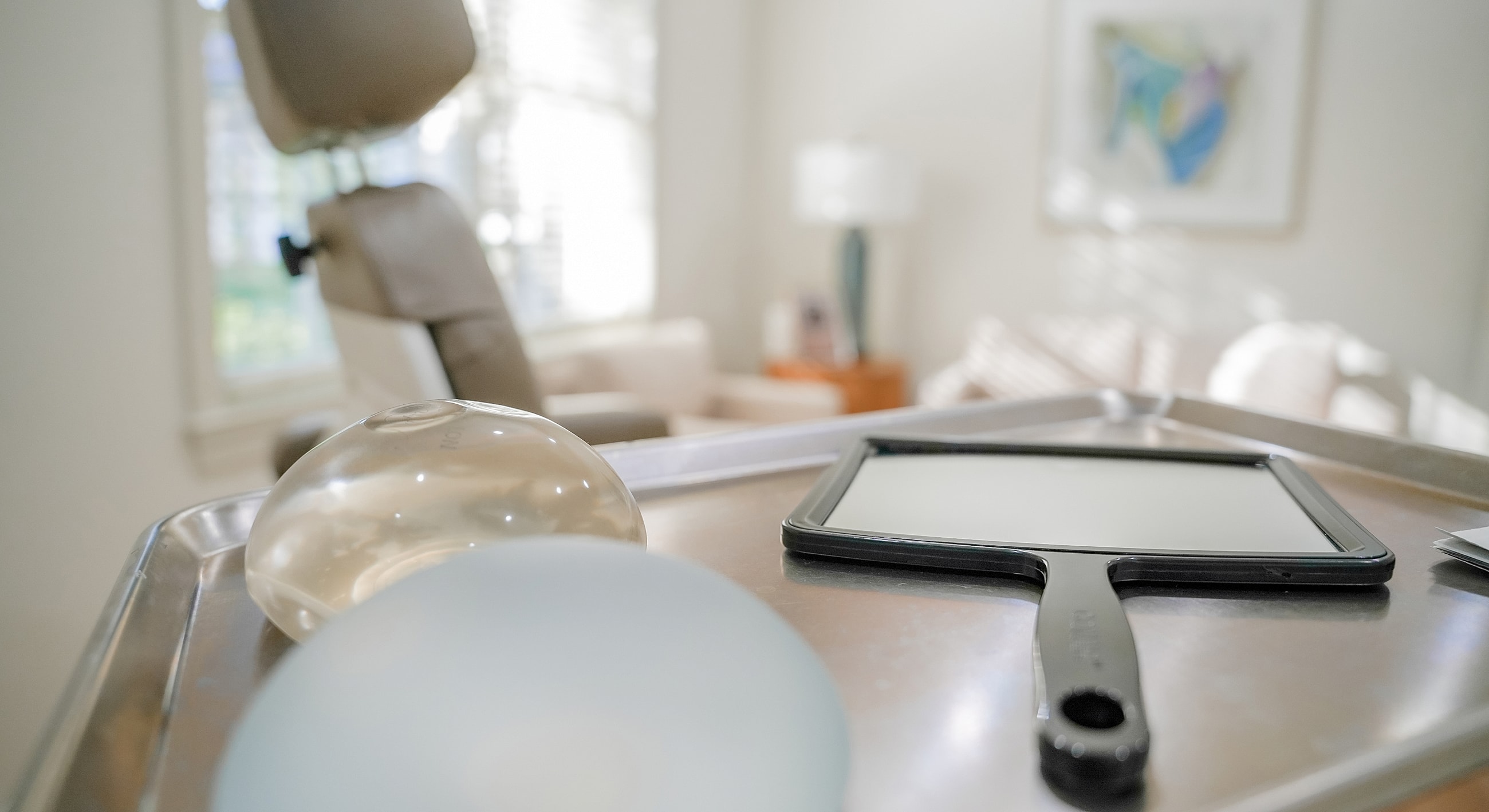 Medical tools on a tray in a bright room.