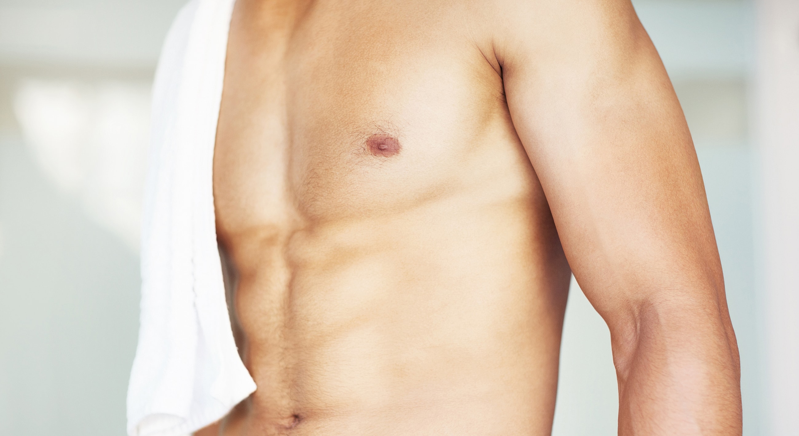 Male torso with towel, soft focus background.
